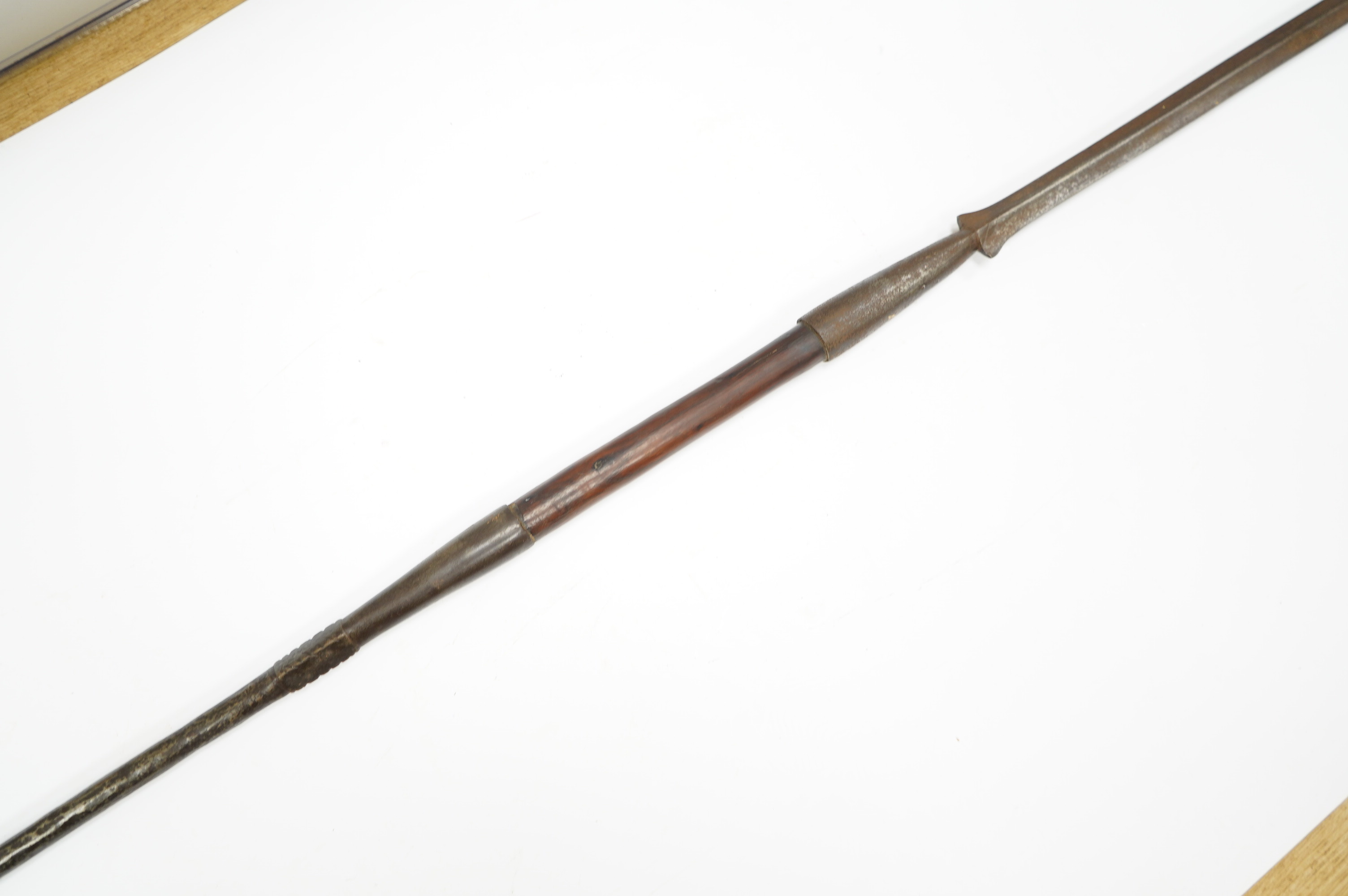 An African spear, with elongated iron tip and short hardwood shaft, 185cm. Condition fair to good, with patination.